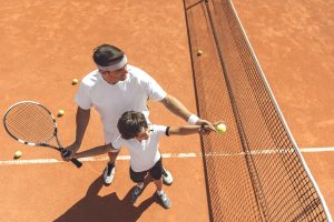 dad and child playing tennis together helping build confidence in children walton academy